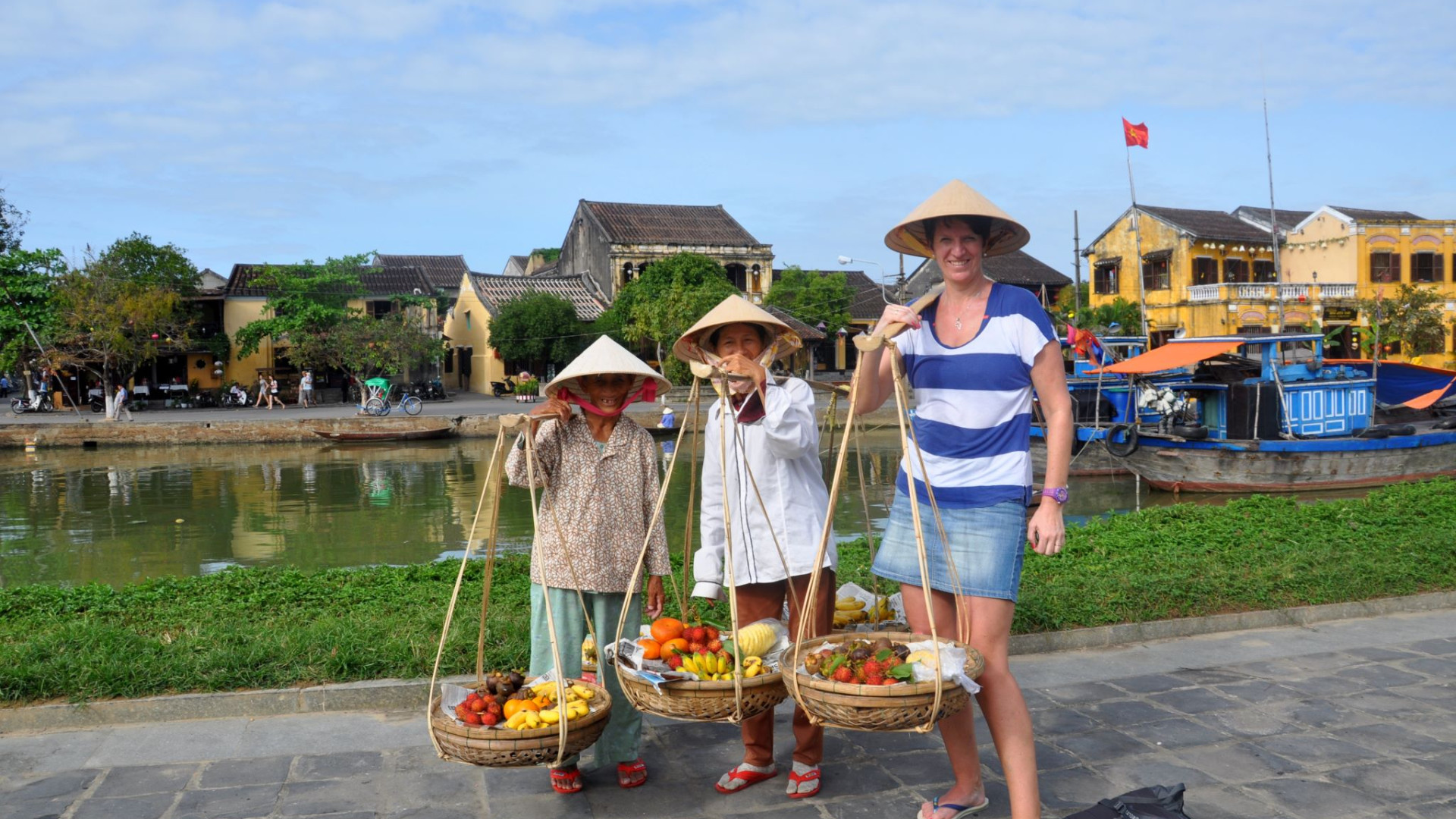 Three women with hats and fruits in Hoi An